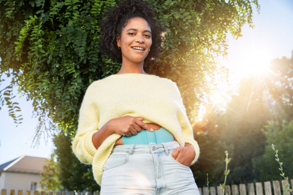Woman wearing the Beurer EM 55 Menstrual Relax+ under her clothes
