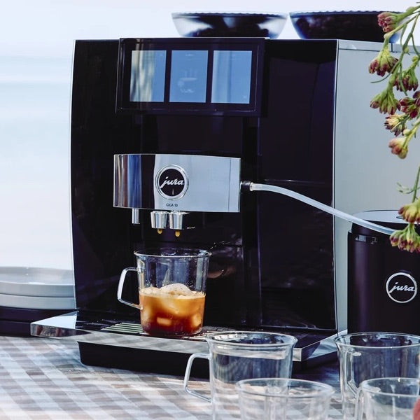 JURA automatic coffee machine pouring an iced coffee outdoors