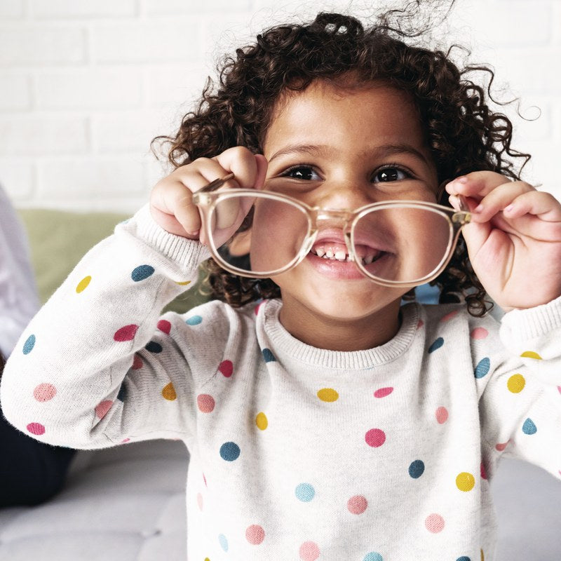 Young girl playing with a pair of glasses