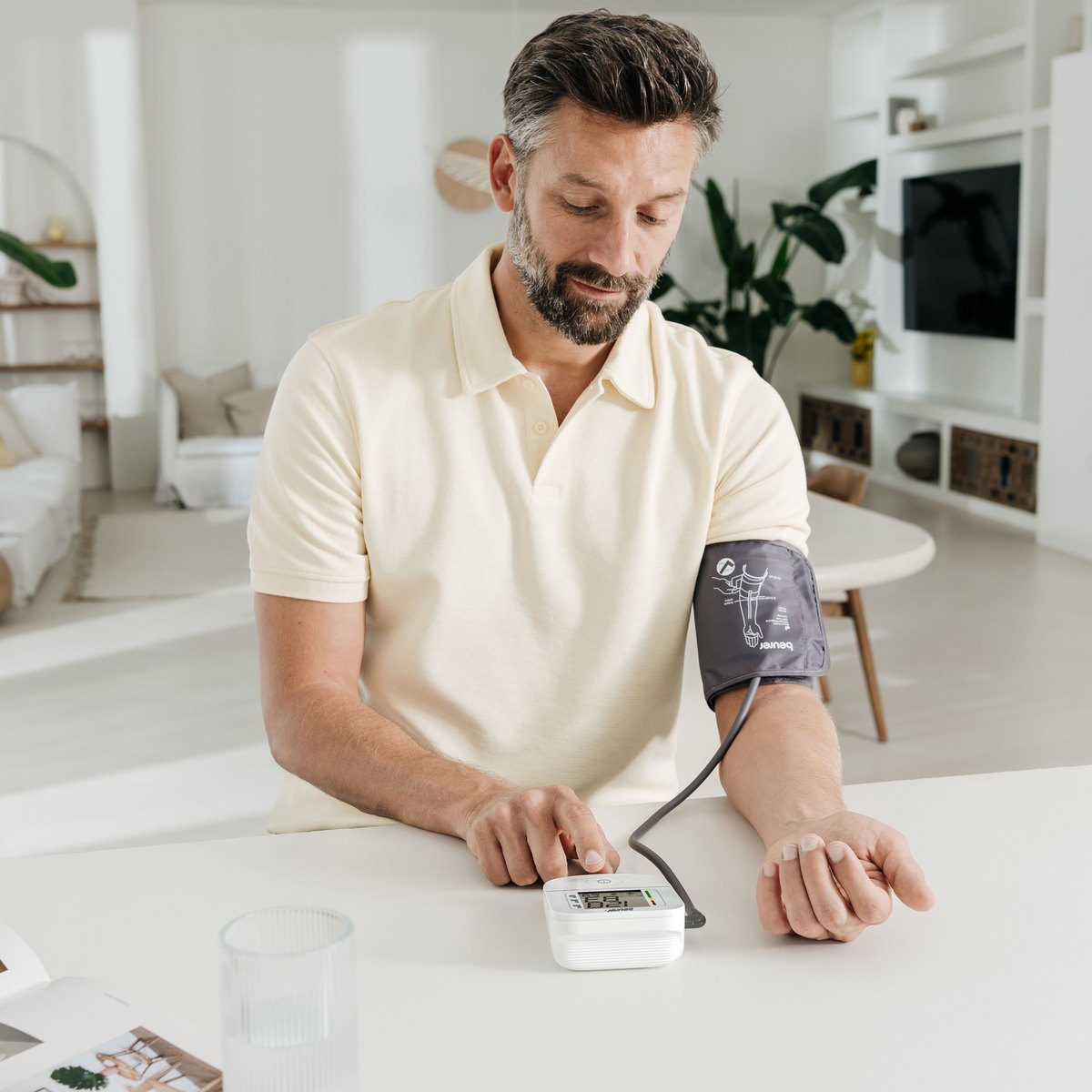 Man taking a blood pressure reading at home with a Beurer upper-arm monitor