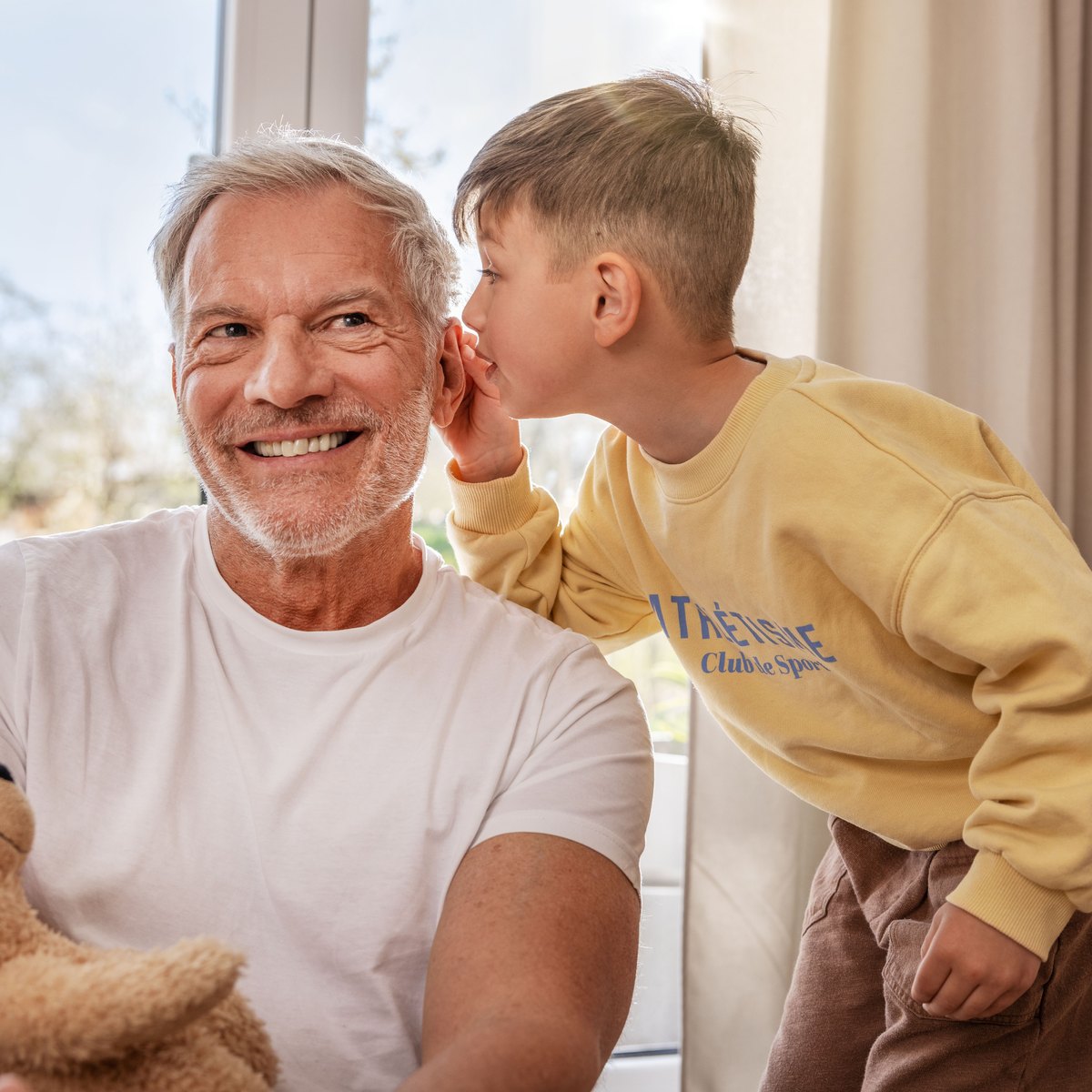 Grandfather listening to a boy whispering, Beurer hearing amplifier