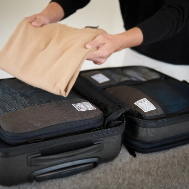 TROIKA packing cubes being packed into a suitcase