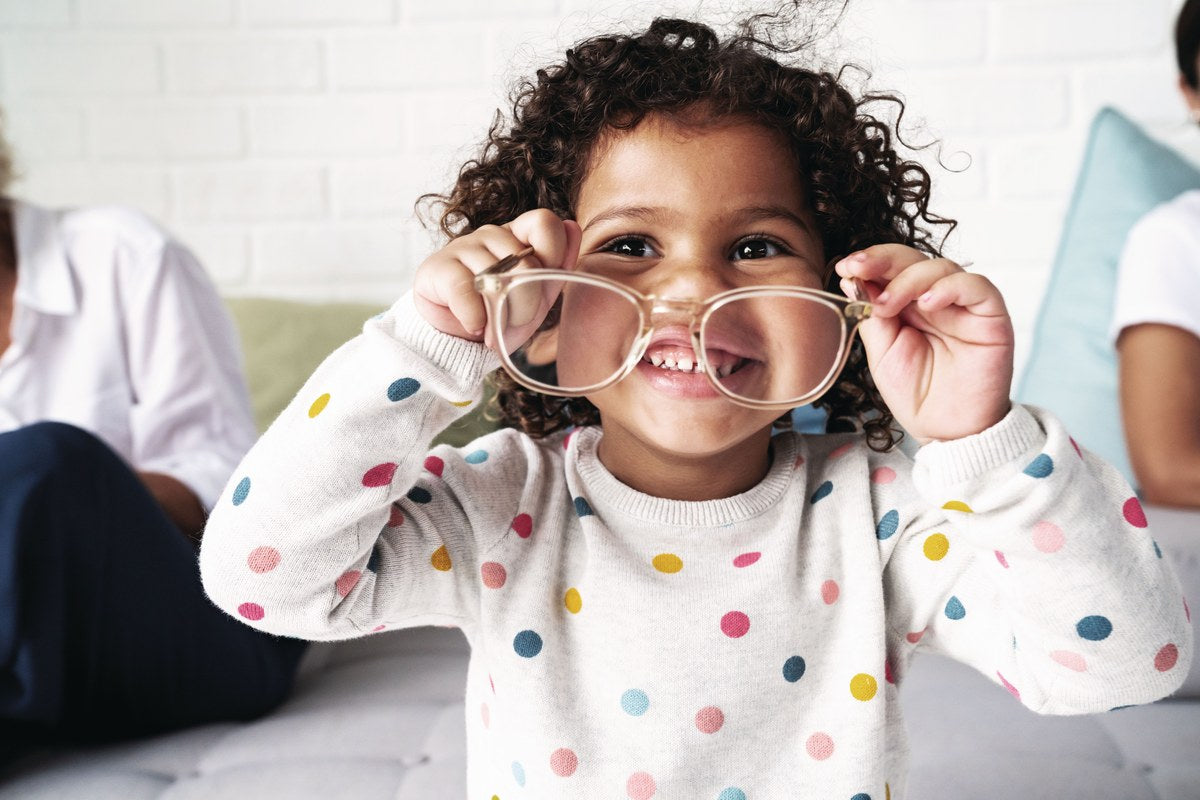 Young girl playing with a pair of glasses
