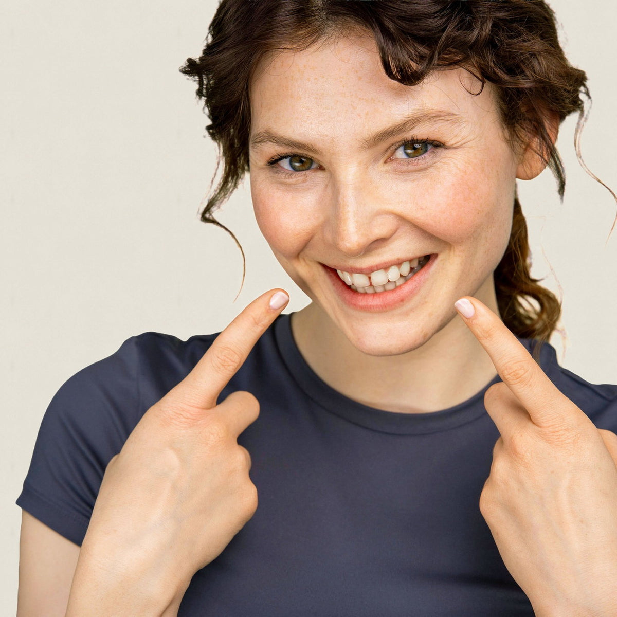 A woman pointing at her smile
