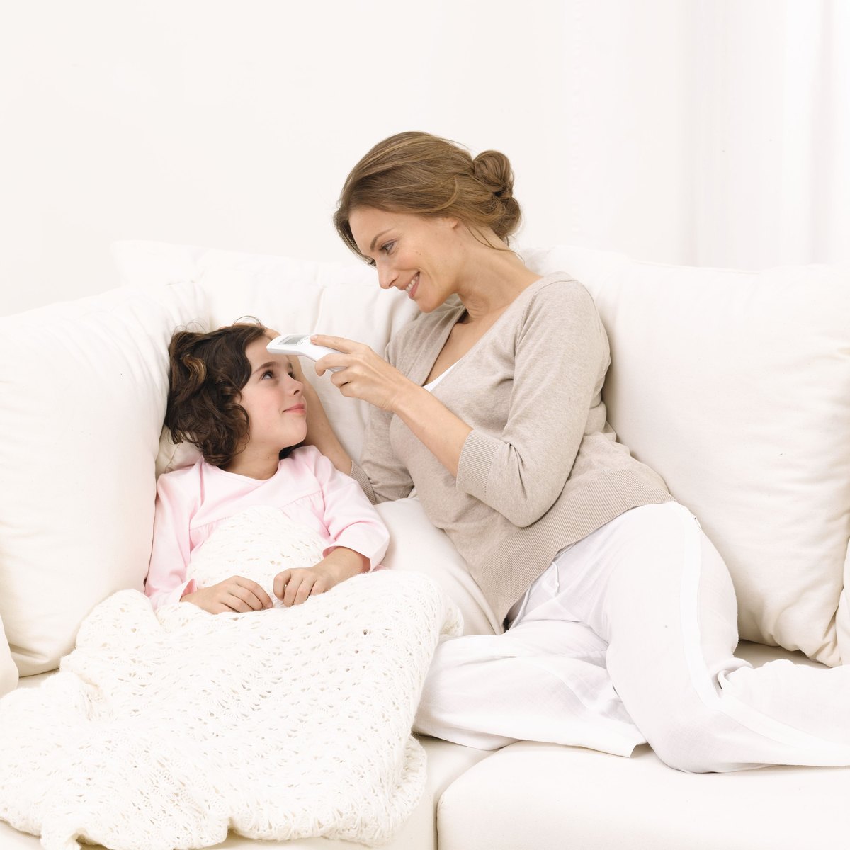 Mother checking her child's temperature with a Beurer forehead thermometer