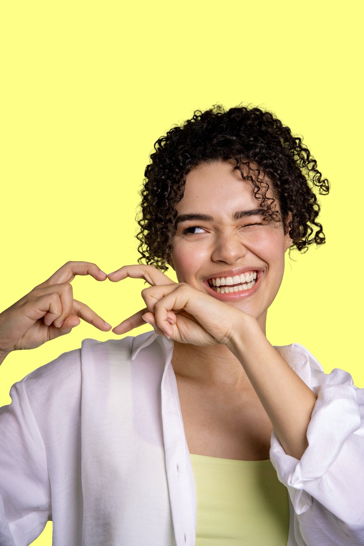 Smiling woman making a heart shape with her hands